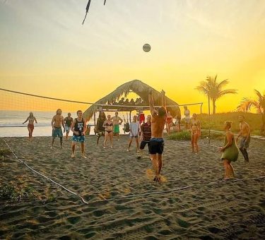Guests playing volleyball at sunset at the Driftwood Surfer in El Paredon, Guatemala