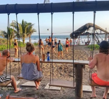 travelers playing volleyball on the El Paredon Beach in Guatemala at the Driftwood Surfer Hostel