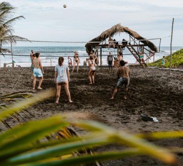 Guests playing volleyball at sunset at the Driftwood Surfer in El Paredon, Guatemala